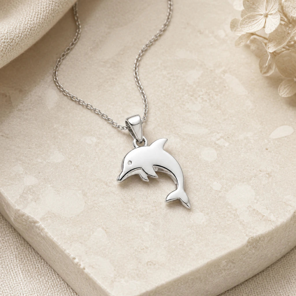 Close-up of silver dolphin pendant showing the sculpted detail