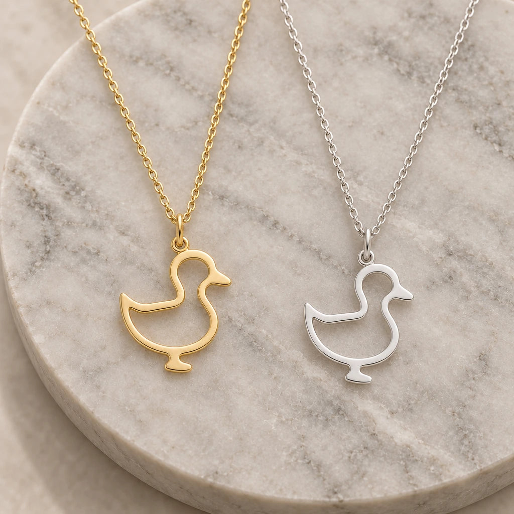 Standing Duck Outline pendant necklace in silver and gold finishes side by side