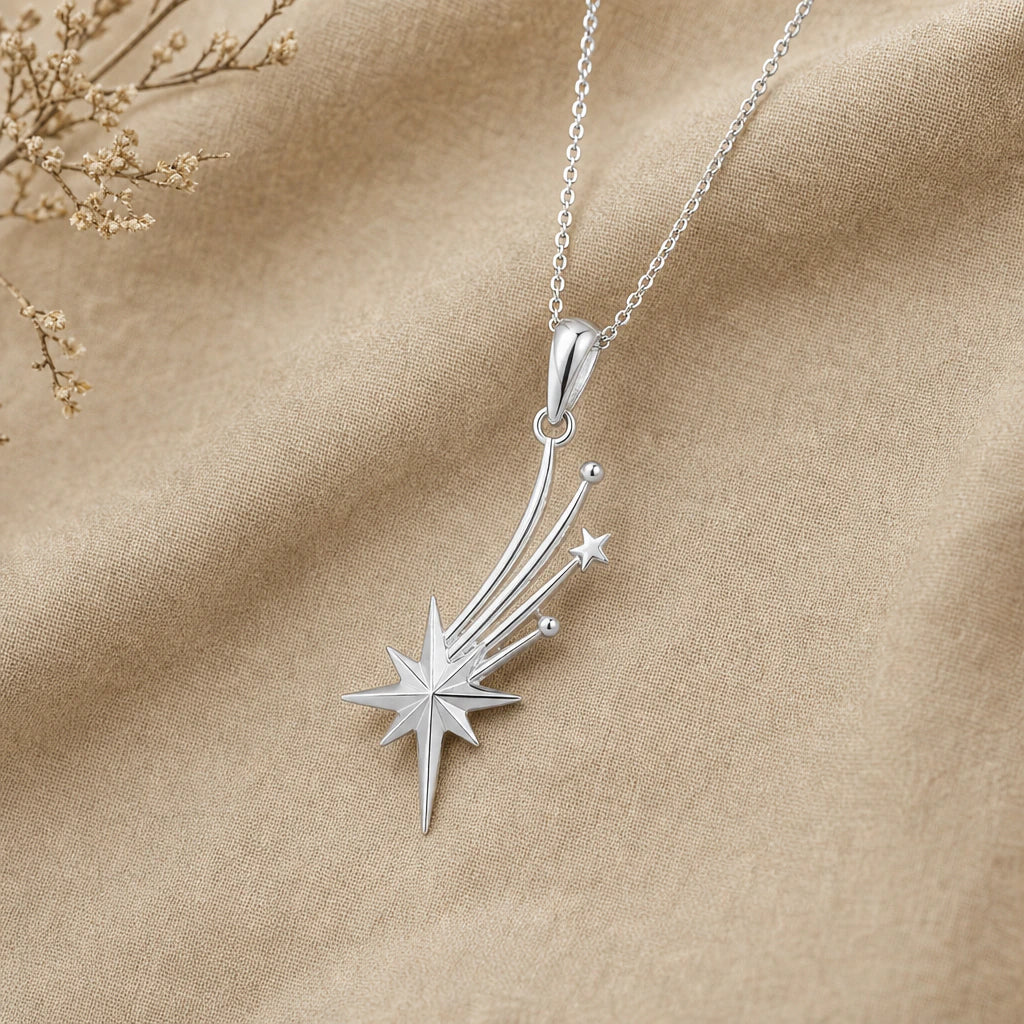 Close-up of silver shooting star pendant with faceted star and three trails