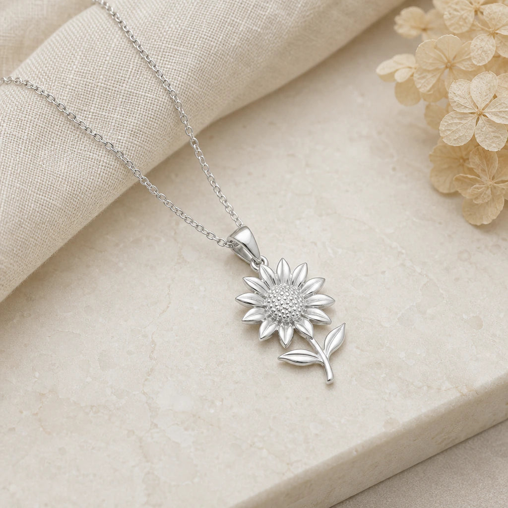 Close-up of silver sunflower pendant showing the sculpted detail
