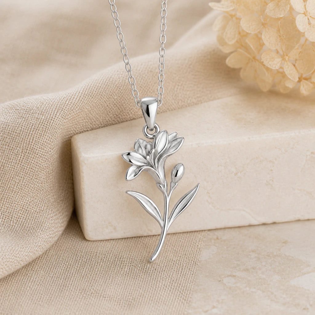 925 sterling silver freesia flower pendant necklace on softly folded cream linen