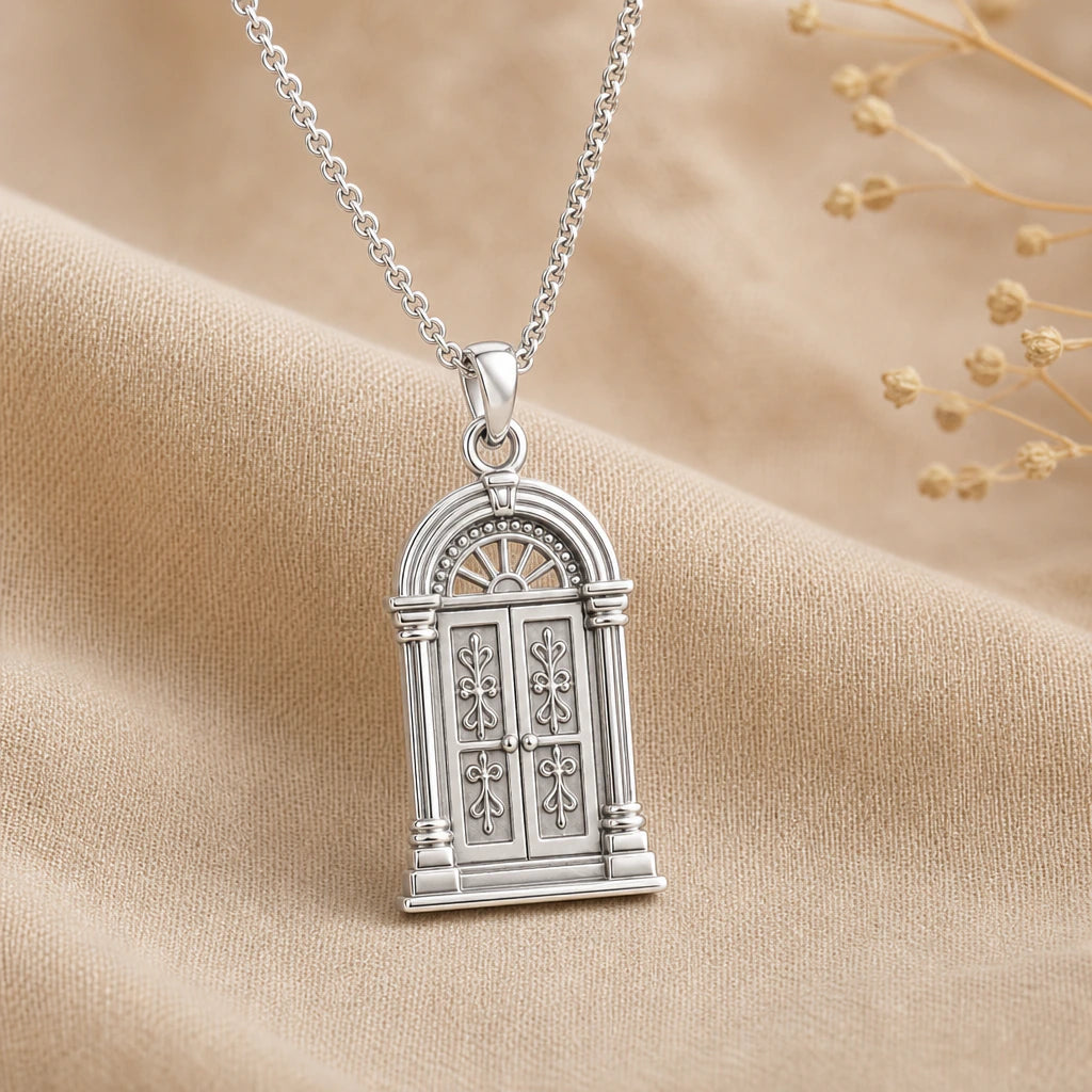 Close-up of silver doorway pendant with arched double doors and columns