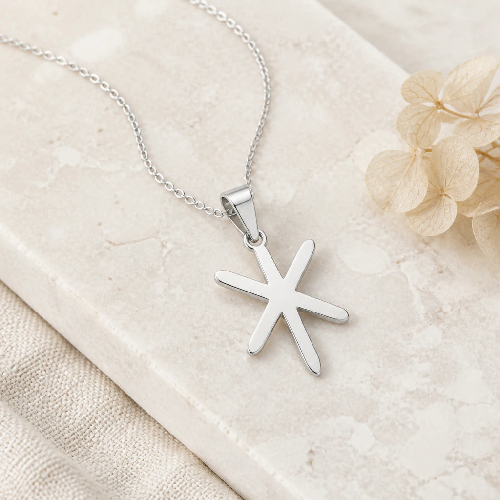 Close-up of silver viking gebo isa bind rune pendant showing the sculpted detail