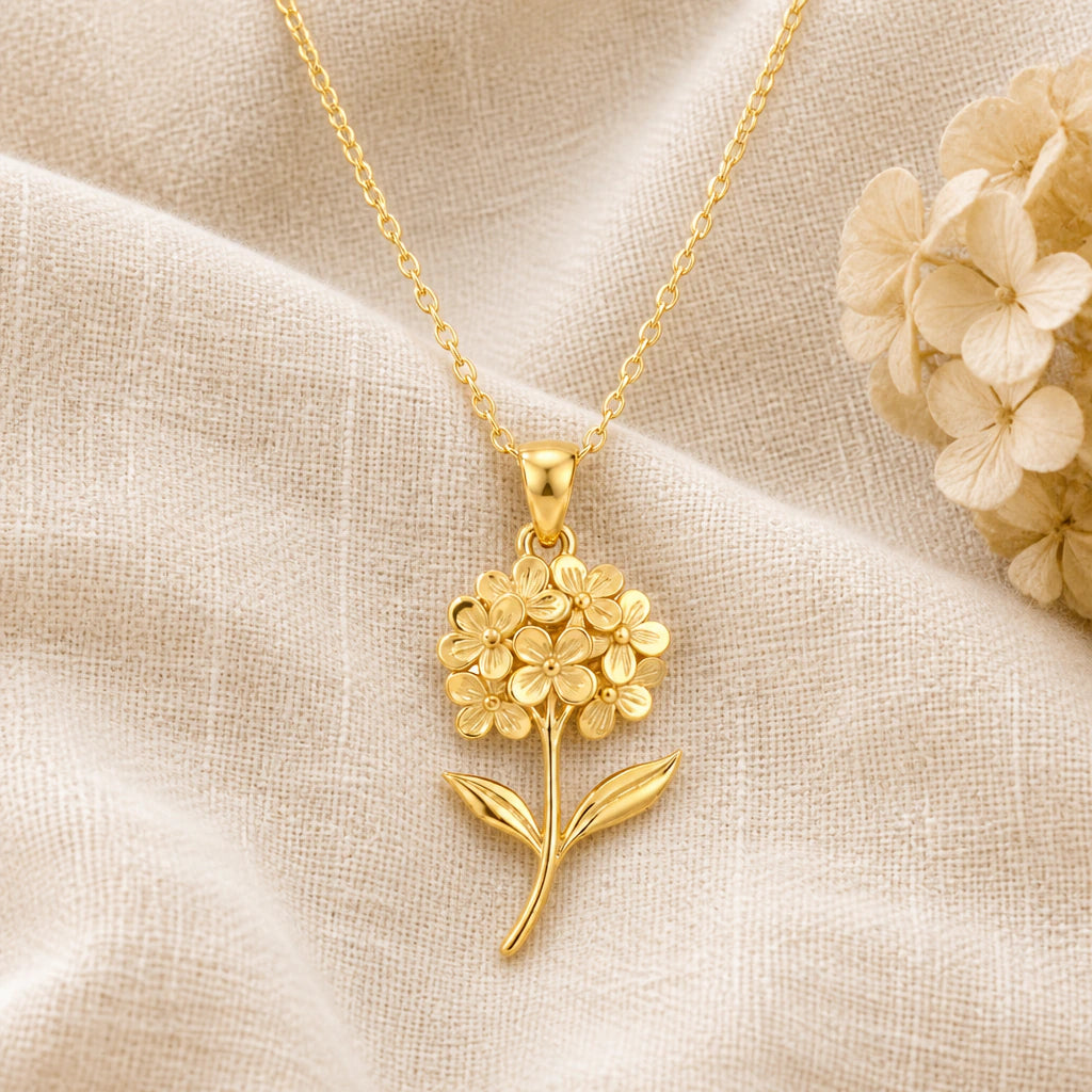 Hydrangea Flower pendant necklace in a warm gold finish on cream fabric