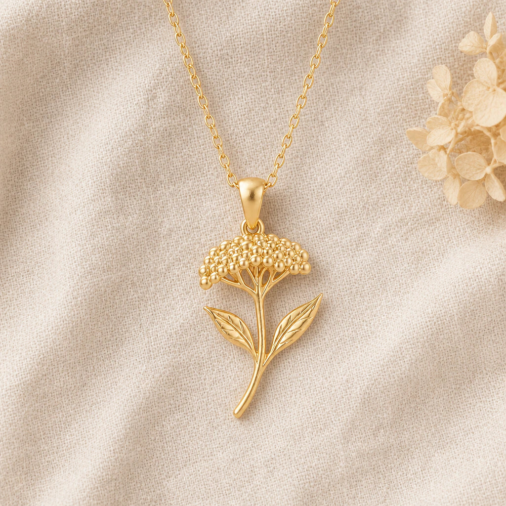 Yarrow Flower pendant necklace in a warm gold finish on cream fabric