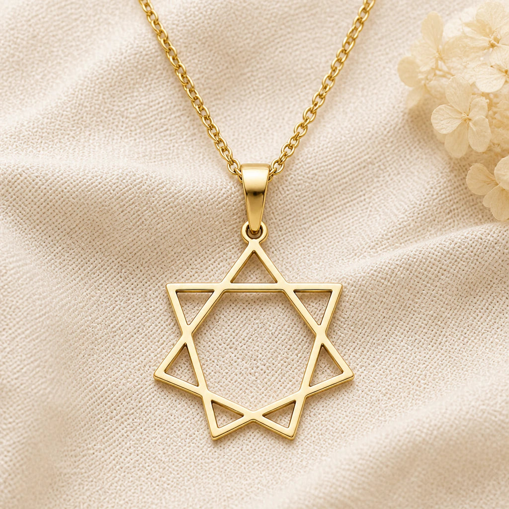 Seven Pointed Star pendant necklace in a warm gold finish on cream fabric