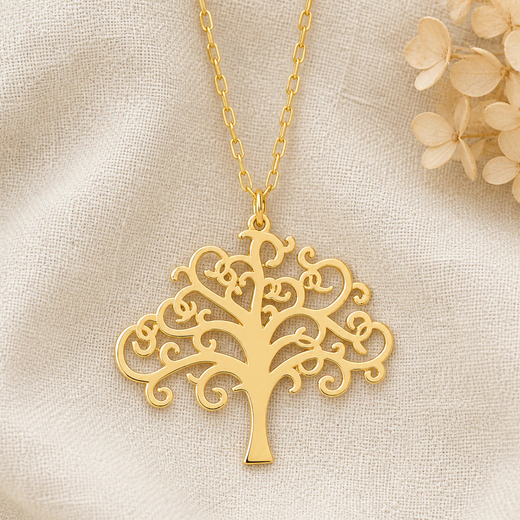 Swirling Tree of Life pendant necklace in a warm gold finish on cream fabric