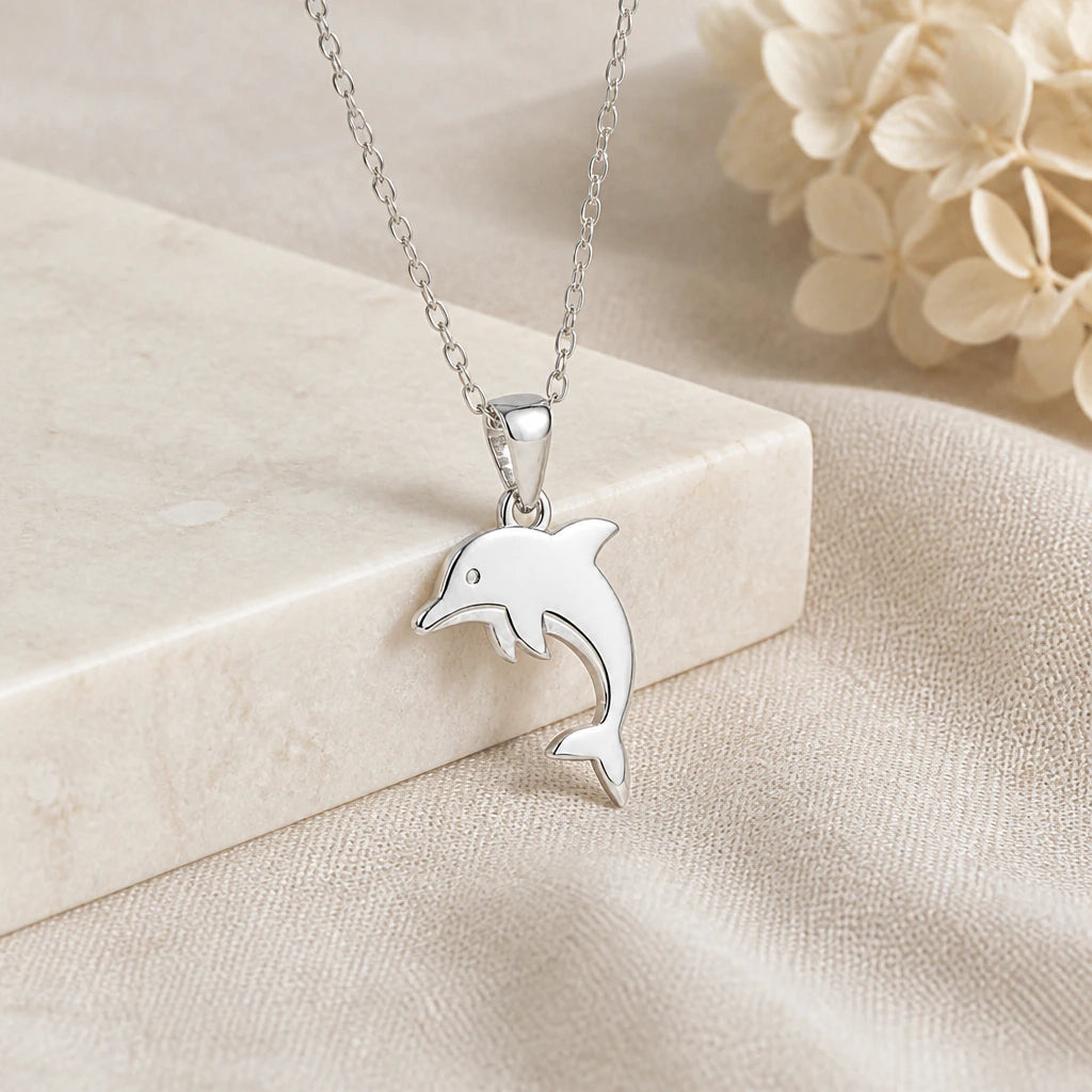 925 sterling silver dolphin pendant necklace on softly folded cream linen