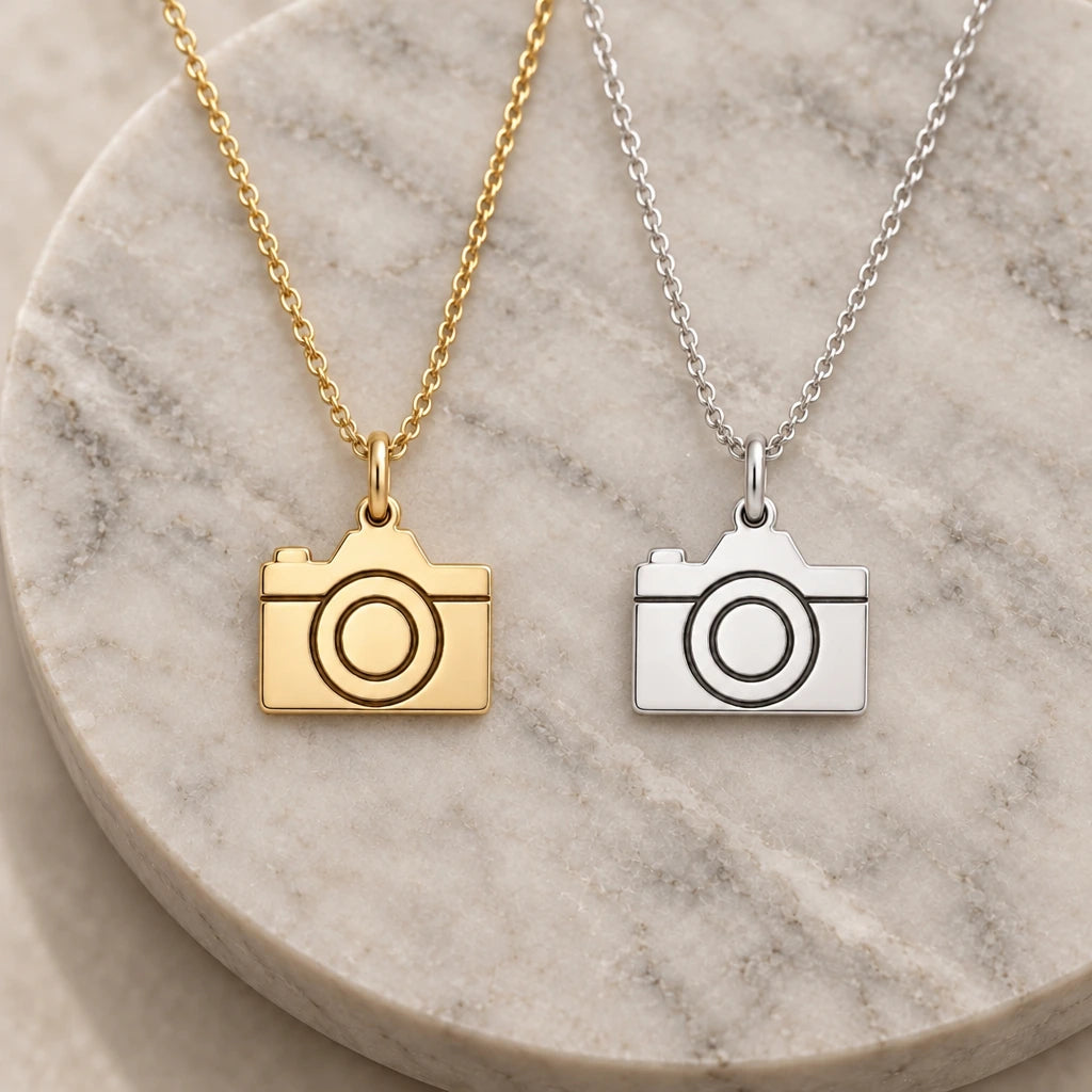 Camera pendant necklace in silver and gold finishes side by side
