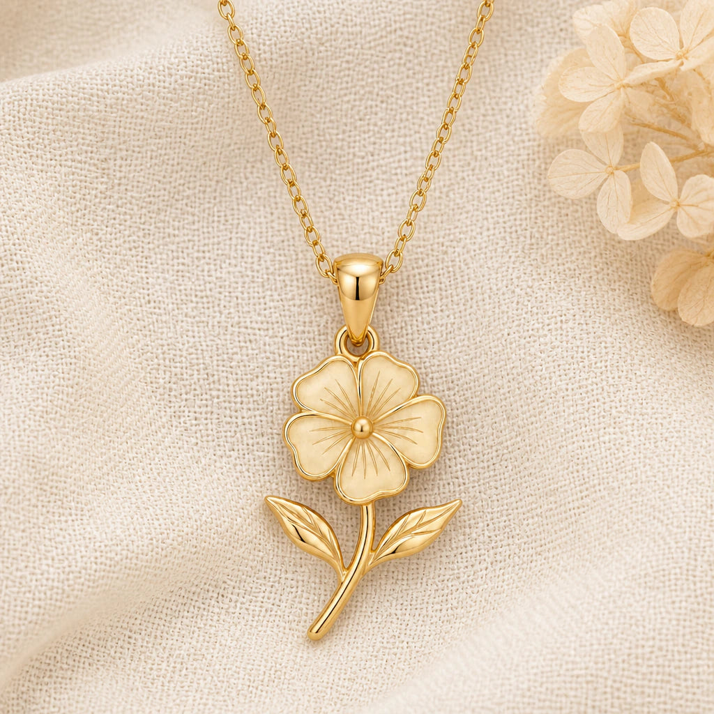 Phlox Flower pendant necklace in a warm gold finish on cream fabric