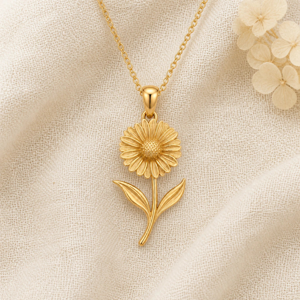 Calendula Flower pendant necklace in a warm gold finish on cream fabric