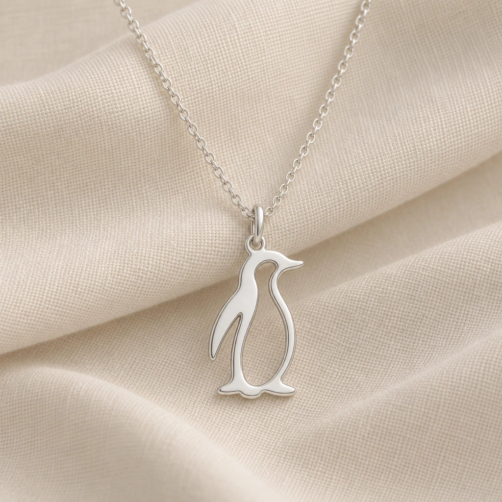 925 sterling silver penguin outline pendant necklace on cream fabric