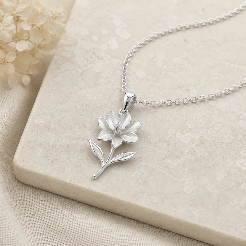 Close-up of silver magnolia flower pendant showing the sculpted detail