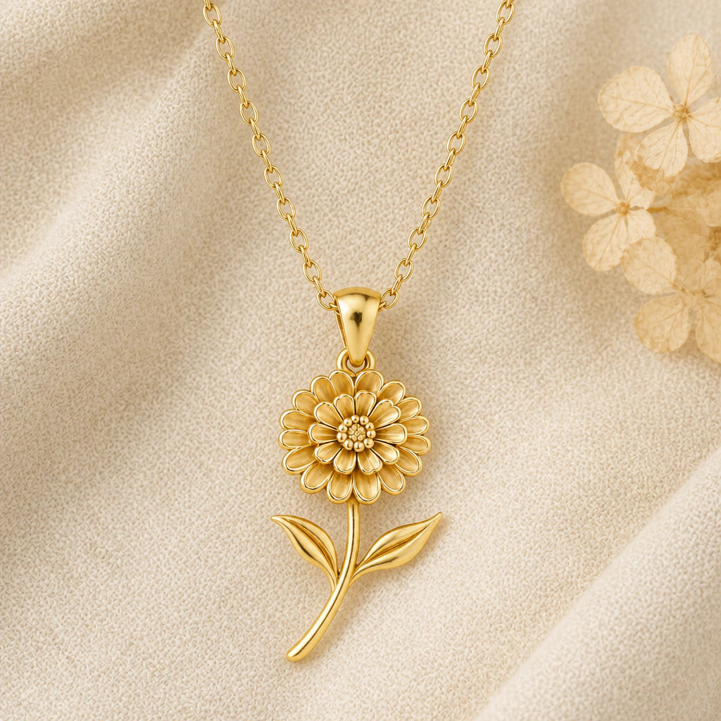 Zinnia Flower pendant necklace in a warm gold finish on cream fabric