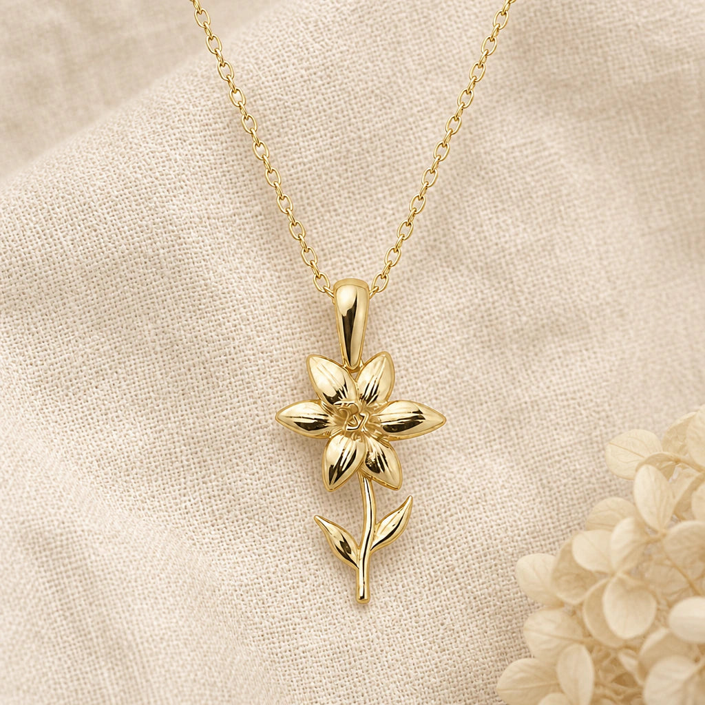 Single Lily Flower pendant necklace in a warm gold finish on cream fabric