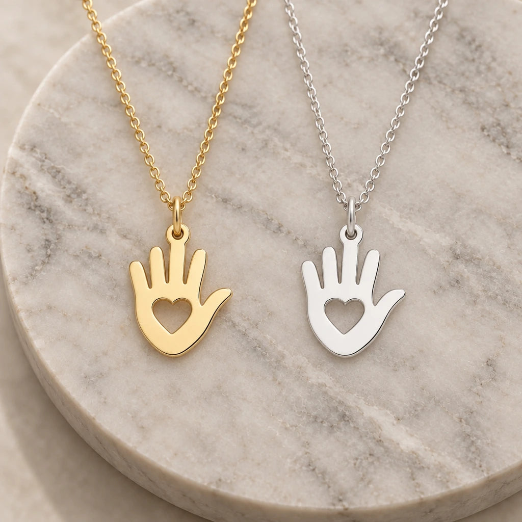 Helping Hand Heart pendant necklace in silver and gold finishes side by side
