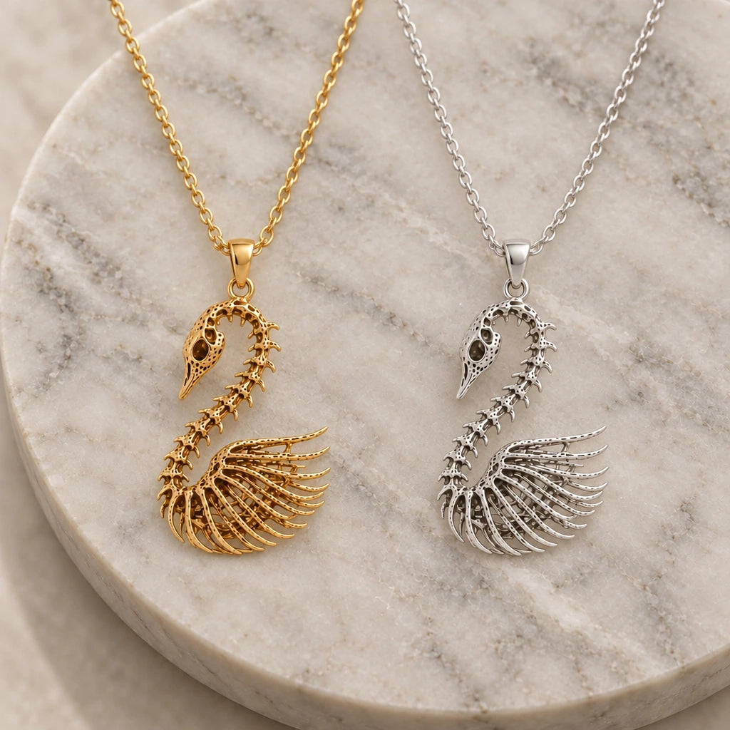 Fossil Swan Skeleton pendant necklace in silver and gold finishes side by side