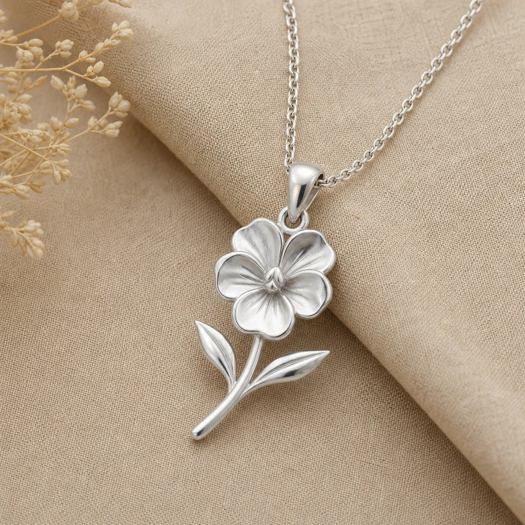 Close-up of silver violet pendant with five veined petals and two leaves
