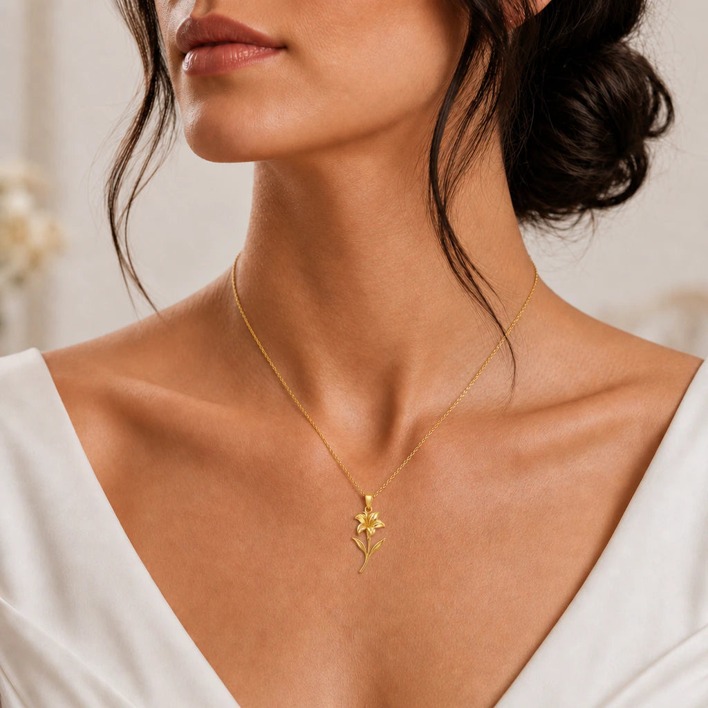 Canna flower pendant necklace in gold finish worn with an ivory dress, close-up