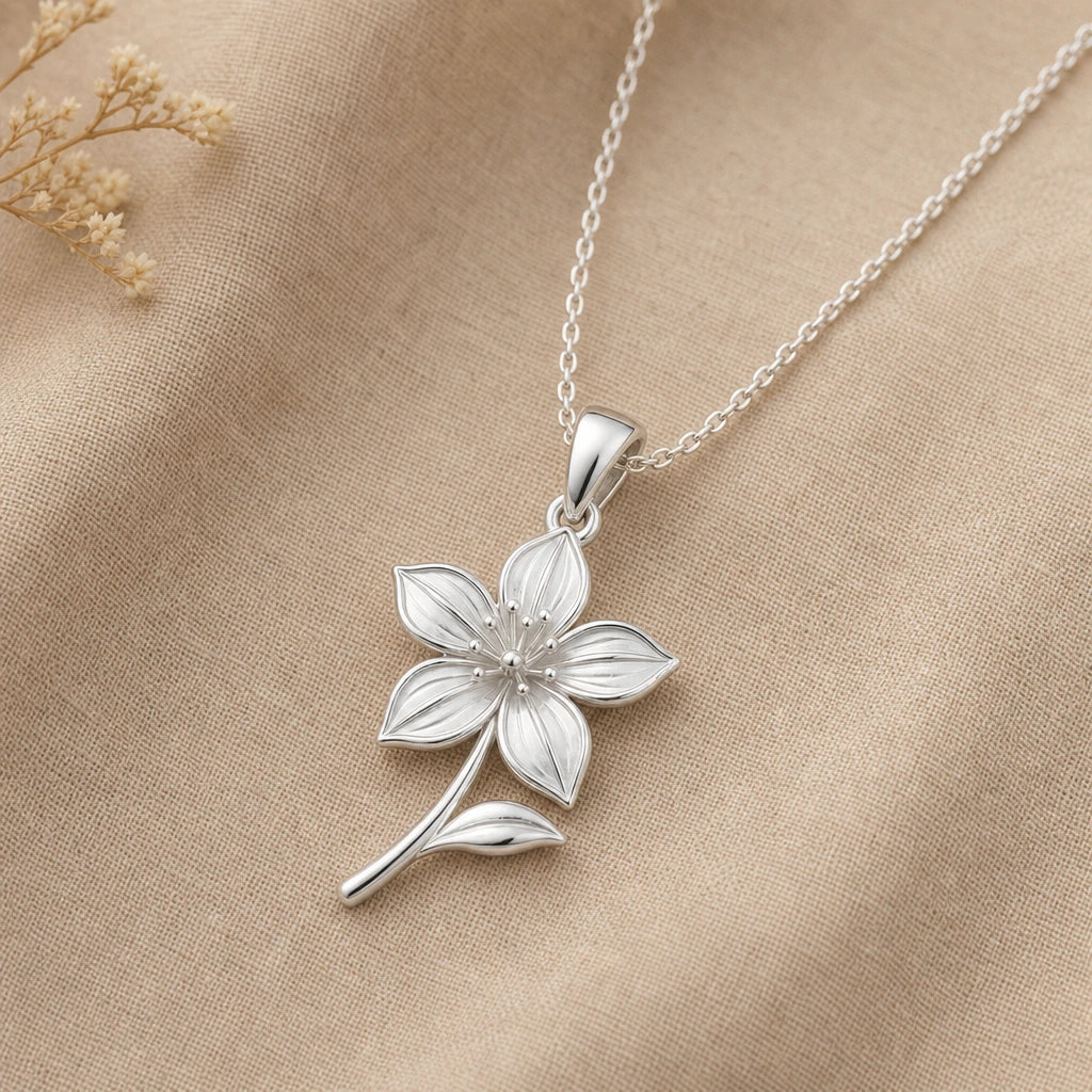 Close-up of silver clematis pendant with five pointed petals and stamens